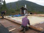 Americorps volunteers and Forest Service staff work on getting the first row of logs installed.